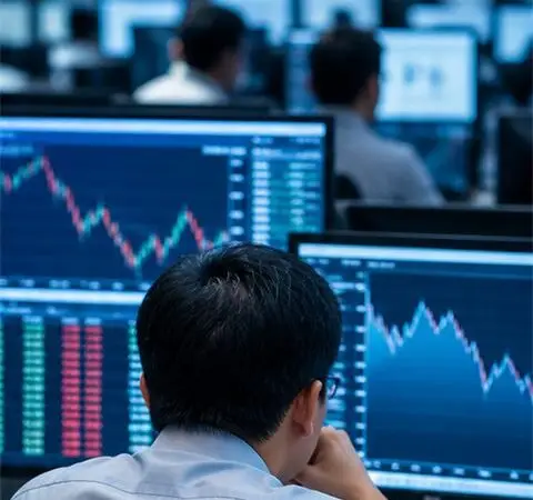 A financial analyst monitors markets across multiple screens.