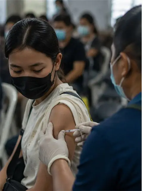 A health worker prepares a vaccine dose at a clinic.