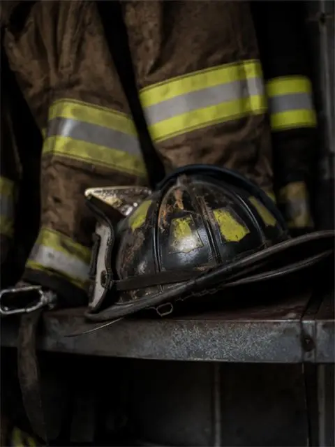 A firefighter's helmet and breathing equipment rest on a vehicle tailgate.